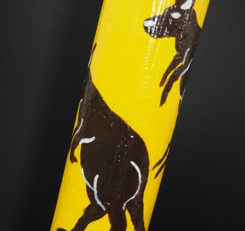 Yellow didgeridoo with black kangaroos