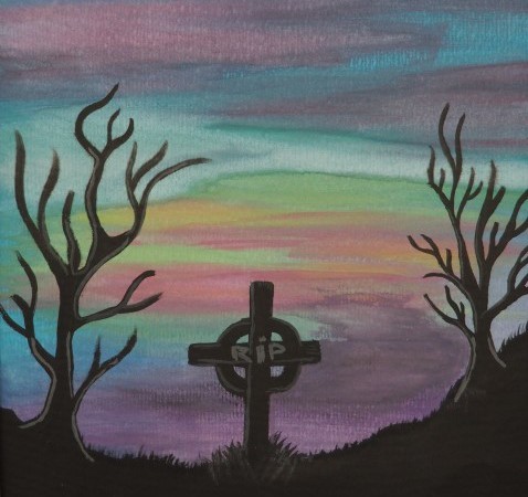 Celtic cross and two bare trees silhouetted against a coloured sky
