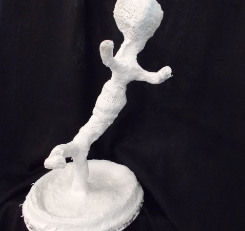 White sculpture of a figure kicking