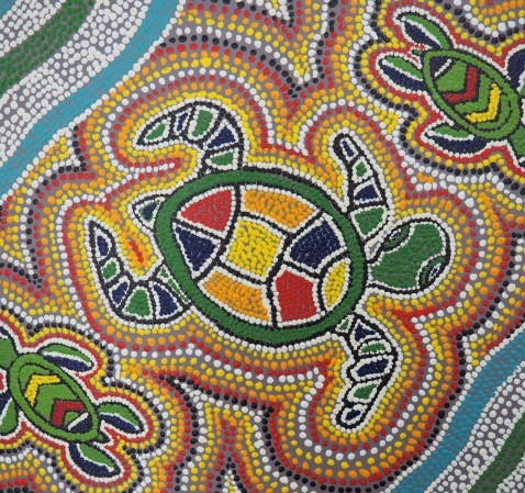 Coloured dot painting of a large turtle with a smaller turtle on each side