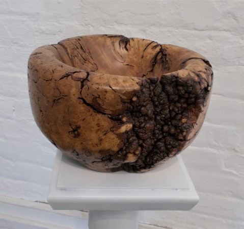 Wooden bowl on a white plinth