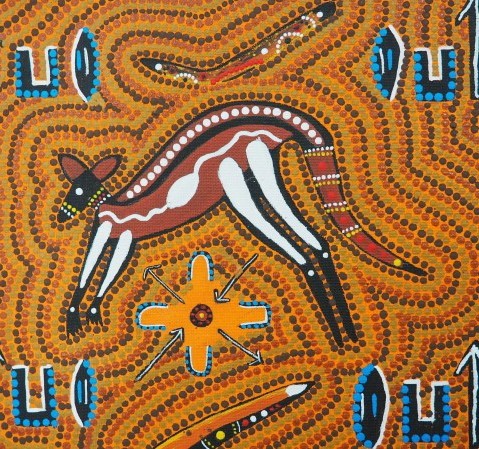 Dot painting of a kangaroo in ochre, white and black, with other shapes in blue and yellow