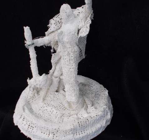 White sculpture of a figure holding a sledge hammer